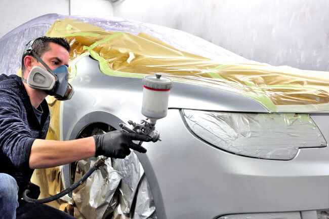 Professional male painting silver car